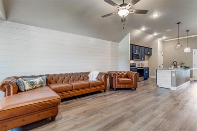 Living room featuring high vaulted ceiling, wood-type flooring, sink, and ceiling fan