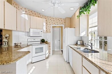 Kitchen with white appliances, white cabinets, a s