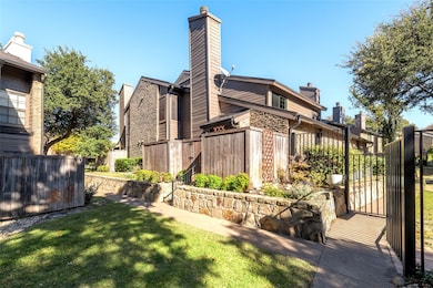 View of home's exterior featuring a chimney and a gate