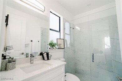 Bathroom featuring a shower with door, vanity, and