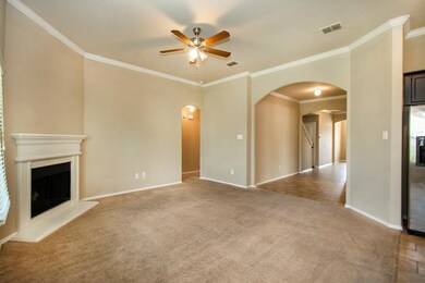 Unfurnished living room with crown molding, carpet floors, and ceiling fan