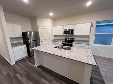 Kitchen with stainless steel appliances, a sink, w