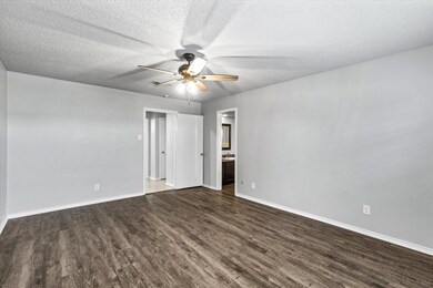 Unfurnished room with ceiling fan, dark hardwood /