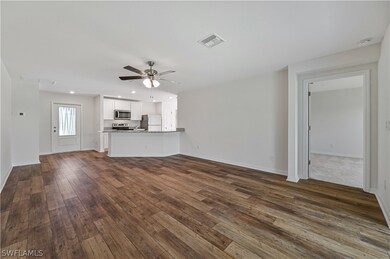 Unfurnished living room featuring dark hardwood /