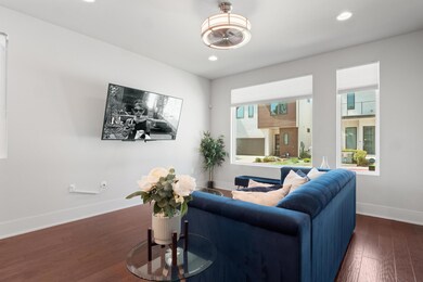 Living area with dark wood-type flooring and recessed lighting