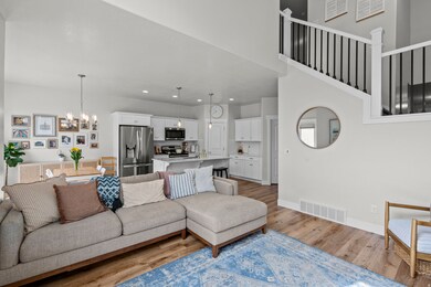 Living room with a chandelier, light wood-type flooring, and recessed lighting