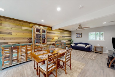 Dining space with wood accent wall, recessed light
