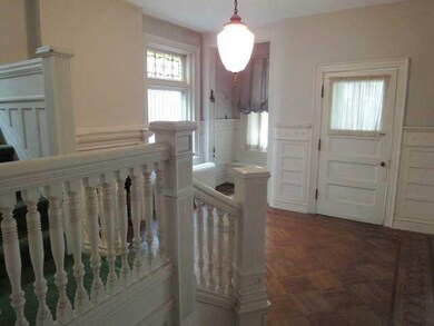 Foyer View of entrance door in large wood-paneled 