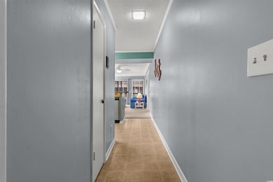 Corridor with light tile patterned flooring, a tex