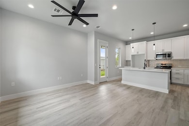 Kitchen with backsplash, a ceiling fan, visible v