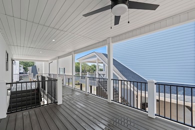 Wooden deck with a water view and a ceiling fan