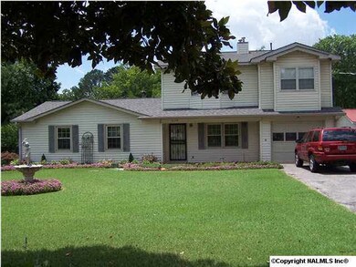 The landscaping is beautiful with the large trees and well kept flowers, lawn and shrubs.