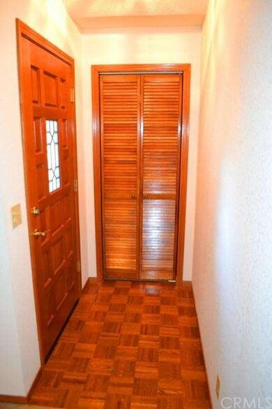 Formal entry with coat closet and parquet floor.