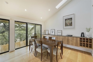 Dining area with high vaulted ceiling, light wood