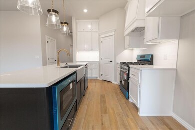 Kitchen with premium range hood, white cabinets, d