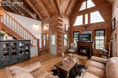 Living room featuring beamed ceiling, high vaulted