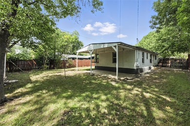 Fenced backyard featuring a carport and a patio a
