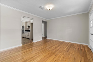 Unfurnished room with crown molding, a textured ce