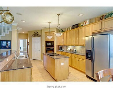 Kitchen. A central island with electric cooktop, endless granite countertops, and a breakfast bar that faces the living room make the spacious kitchen a great space to release your inner chef!