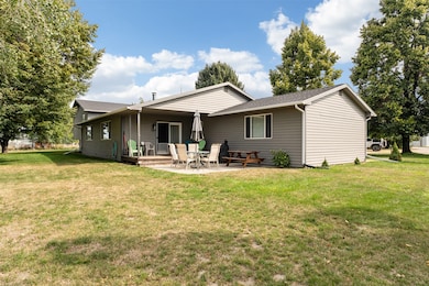 Rear view of house with roof with shingles, a lawn, a patio area, and a deck