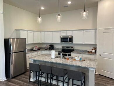 Kitchen featuring stainless steel appliances, dark wood finished floors, hanging light fixtures, and recessed lighting