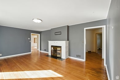 Living room with light wood flooring and a fireplace with hearth.
