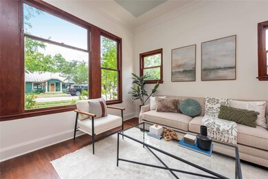 Living area with crown molding, baseboards, and w