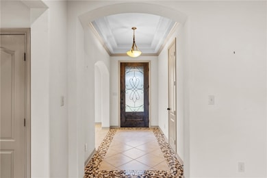 Foyer entrance with arched walkways, crown molding