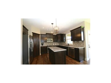 Sunny kitchen includes upgraded granite, tile back