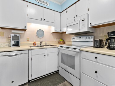 Kitchen featuring a sink, light countertops, white