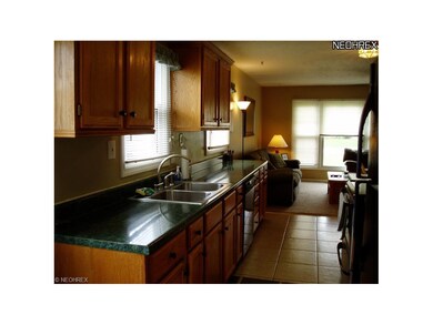 The updated galley kitchen has oak cabinets and ce