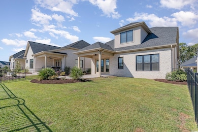 Rear view of house with a patio area and a lawn