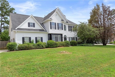 View of front of house with stucco siding and roof with shingles