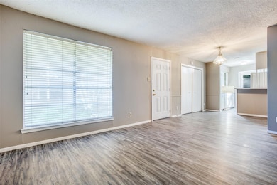 Unfurnished living room with baseboards, a textur
