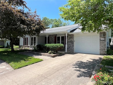 Single story home featuring concrete driveway, a shingled roof, an attached garage, a porch, and brick siding