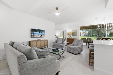 Living room featuring a chandelier, light tile patterned flooring, and ceiling fan