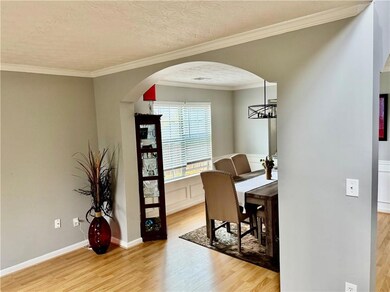 Dining area with light wood-style floors, arched w