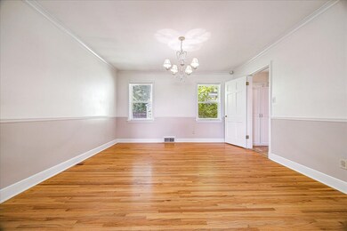 Unfurnished dining area with ornamental molding, light wood-type flooring, and a chandelier