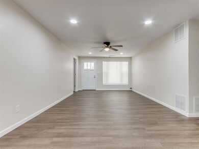 Unfurnished living room with ceiling fan and light