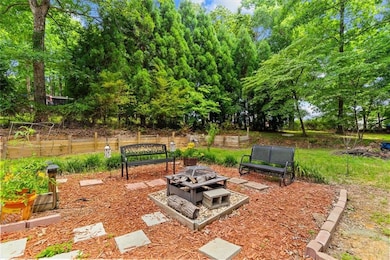 View of yard with a fire pit and view of wooded area