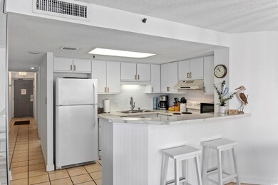 Kitchen featuring white fridge, light tile pattern