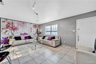 Living room featuring rail lighting, light tile patterned floors, and baseboards