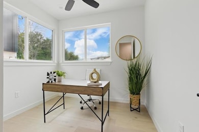 Home office featuring baseboards, a ceiling fan, 