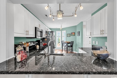 Kitchen featuring track lighting, a textured ceili