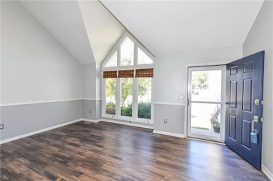 Entryway featuring dark wood-style floors and high vaulted ceiling