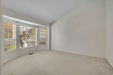 Carpeted empty room featuring vaulted ceiling and baseboards