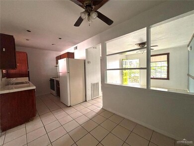 Kitchen with range, freestanding refrigerator, ceiling fan, visible vents, and a sink