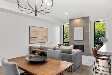 Dining area with a fireplace, wood finished floors, recessed lighting, and a chandelier