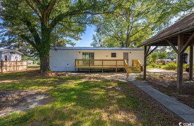 Back of house featuring a wooden deck and metal roof