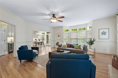 Living room featuring wine cooler, ceiling fan wit